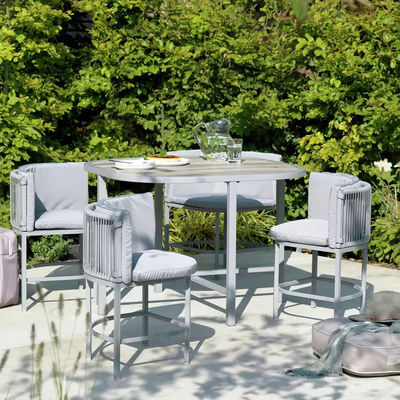 Maximice su espacio al aire libre con este conjunto de comedor de tejido de ratán y acero que ahorra espacio