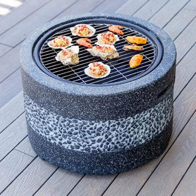 Fuego de jardín en el patio exterior con parrillas de piedra artificial y carbón