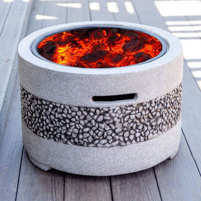 Fuego de jardín en el patio exterior con parrillas de piedra artificial y carbón