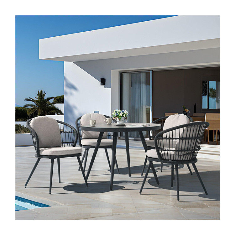 Set de comedor al aire libre con mesa redonda de vidrio templado y sillón de tejido de cuerda